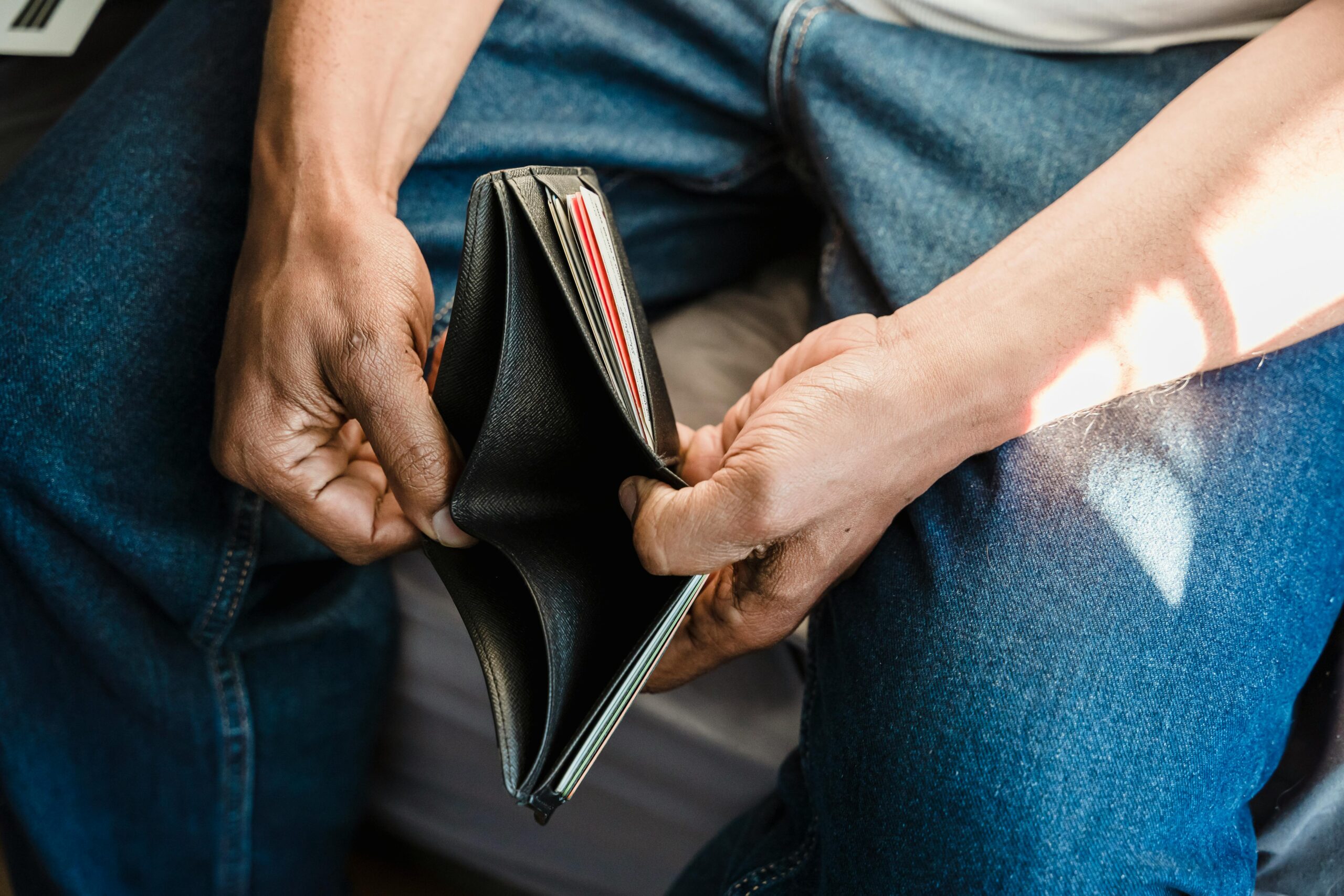 A man holding open an empty wallet